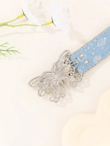 Macro view of light blue denim belt with silver butterfly buckle and stud details