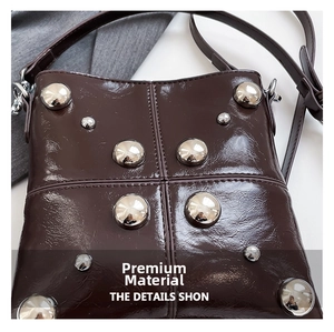 Macro view of dark coffee crossbody bag featuring silver rivets and oil wax leather texture