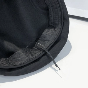 Detailed close-up of black beret interior with adjustable drawstring and fabric texture