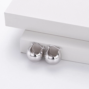 Detailed close-up of S925 sterling silver ball earrings on a white stone background