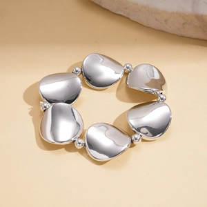 Detailed macro view of silver geometric irregular metal pieces on a polished bangle set