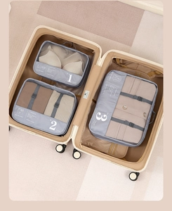 Close-up of grey travel organizers with breathable mesh inside a beige suitcase