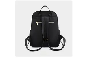 Vista posteriore dello zaino in nylon nero con spallacci regolabili e tasca dorata