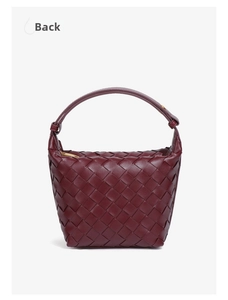 Close-up of wine red woven leather texture and gold zipper detail on hand-woven bag