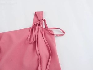 Détail de la conception de l'épaule nouée réglable sur une robe courte rose
