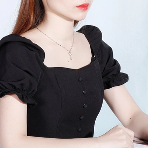 Silver titanium steel necklace featuring a clover key pendant shown on a model neck