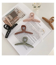 Detailed view of matte resin hair claws in assorted colors on an open magazine page