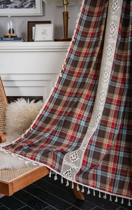 Detailed macro view of woven plaid fabric texture with lace trim and tassel edge