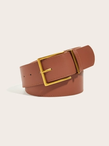 Dettaglio di una cintura in pelle marrone vintage con fibbia in metallo dorato lucido