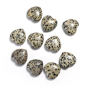 Detailed view of ten heart-shaped dalmatian jasper stone beads on a clean white background