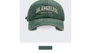 Close-up detail of vintage washed green cotton baseball cap with white LOS ANGELESS embroidery