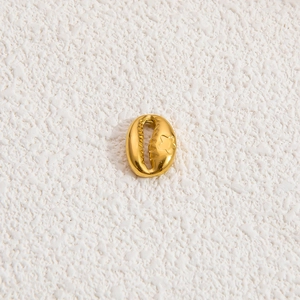 Close-up of golden seashell pendant with star relief detail and metallic finish