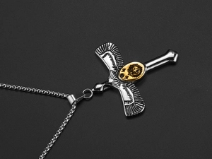 Detail of vintage eagle cross pendant with gold center on a silver box chain necklace