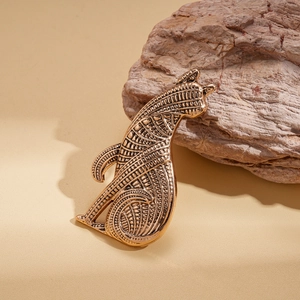 Macro shot of vintage gold cat brooch with antique texture and intricate engraving details