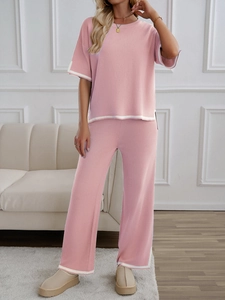 Pink knit set with short sleeve top and wide leg pants featuring white trim details