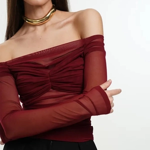 Detail of off-shoulder mesh top in burgundy with chic ruched sleeves and sheer texture