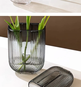 Detailed view of U-shaped dark gray glass vase with vertical striped texture and modern finish