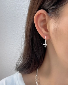 Close-up of minimalist S925 sterling silver cross earring with zircon on earlobe