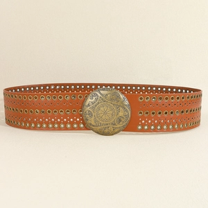 Detail eines breiten braunen Boho-Ledergürtels mit Metallösen und Messingschnalle