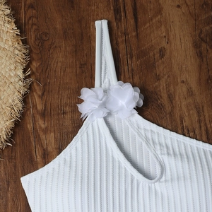 Close-up of white ribbed one-piece swimwear featuring 3D chiffon floral strap detail