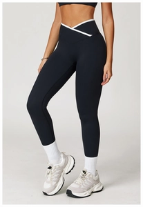 Detail van de high-waist yogabroek met gekruiste taille en witte contrasterende biesjes