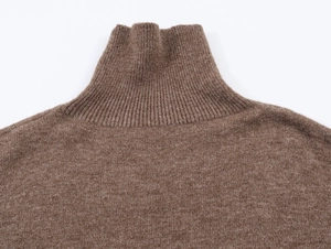 Gros plan du col roulé côtelé et de la texture en maille fine sur un pull marron foncé