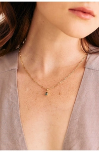 Detailed view of 18K gold plated paperclip chain with emerald green rectangle gemstone