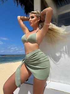 Detail of sage green waffle texture fabric on three-piece bikini set with wrap skirt