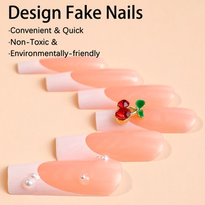 Unghie finte french con ciliegie 3D, perle e punte bianche su una base color nudo