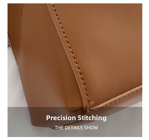 Detail shot of precise stitching on a brown leather shoulder bag showing quality craft
