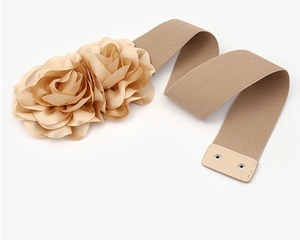 Detail of beige elastic waist belt featuring satin flower decorations and snap buttons