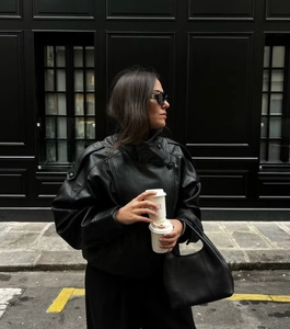 Gros plan d'une veste de motard oversize noire avec revers et détails de zip métallique