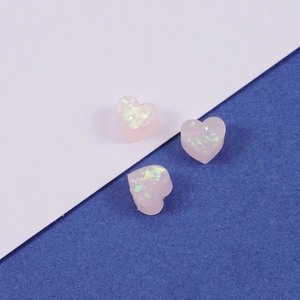Macro shot of three pink heart-shaped synthetic opal resin beads with 1.5mm holes