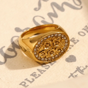 Detail of a vintage 18K gold-plated signet ring with floral relief and diamond accents