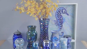 Detail of blue and purple mosaic glass candle holders and vases with silver accents