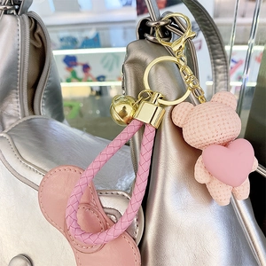 Pink heart bear keychain with woven texture hanging on silver bag luxury accessory