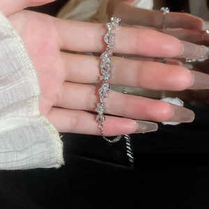 Detail of silver floral bracelet with vine-shaped zircon inlay and adjustable chain