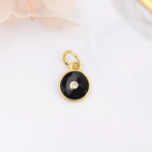 Macro shot of circular evil eye pendant with black enamel and sparkling zircon detail