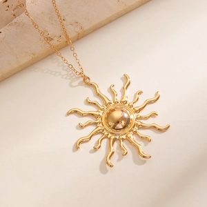 Macro shot of sunburst pendant with golden metallic rays and a delicate link chain