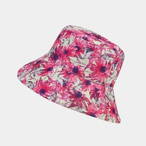 Close-up detail of double-sided bucket hat with vibrant red and pink floral sun flower patterns