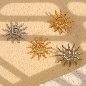 Vue détaillée de boucles d'oreilles soleil dorées et argentées avec spirale