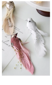 Macro detail of glittered decorative birds with real feathers for Christmas tree decor