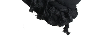 Detailed view of black satin-lined beanie with braided tassels and woven texture finish