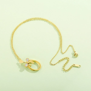 Close-up of golden stainless steel necklace with sparkling rhinestone bow pendant