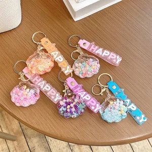 Creative colorful shell drifting bottle keychains with happy wristbands on wooden surface