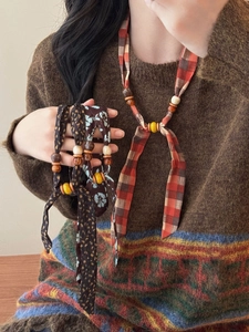 Detail of ethnic fabric necklaces with wooden beads and vintage bohemian floral prints