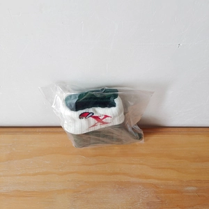 Macro detail of dark green knit Christmas stocking with festive embroidery in clear packaging