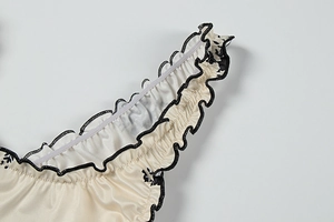 Detailed macro shot of ruffled edges and floral print on premium satin fabric