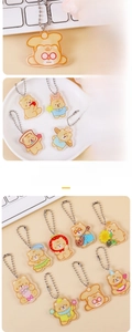 Macro detail of cute cream bear acrylic keychains with durable silver metal ball chains