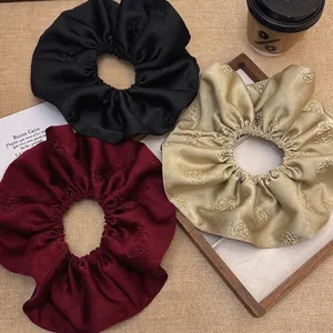 Three-piece jacquard satin scrunchies set with rose patterns in black, red, and champagne